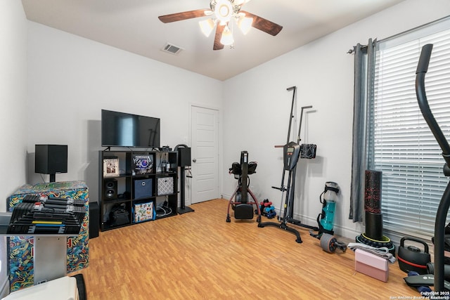 exercise room featuring visible vents, baseboards, a ceiling fan, and wood finished floors