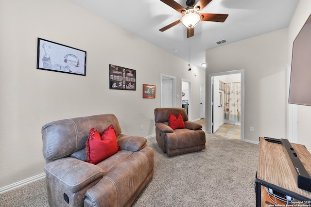 living area featuring baseboards, a ceiling fan, visible vents, and light carpet