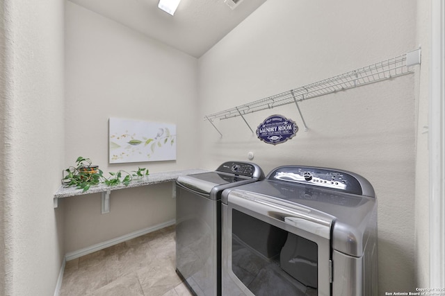 laundry room with laundry area, baseboards, and washer and clothes dryer