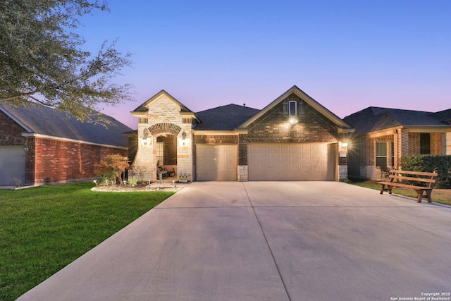 view of front facade with a front yard, a garage, stone siding, and driveway