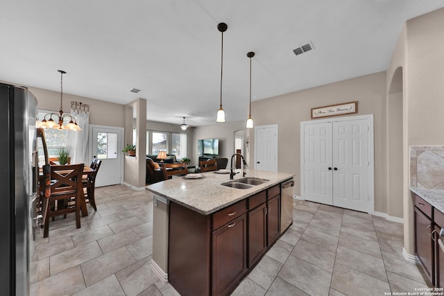 kitchen with visible vents, a sink, dark brown cabinetry, stainless steel dishwasher, and fridge with ice dispenser