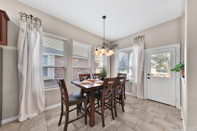 dining space with a chandelier, light tile patterned floors, and baseboards