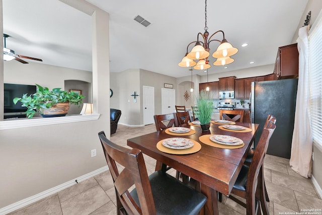 dining room featuring light tile patterned flooring, ceiling fan with notable chandelier, visible vents, and baseboards