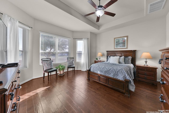 bedroom featuring visible vents, a raised ceiling, baseboards, and wood-type flooring