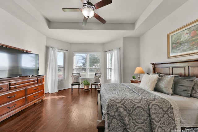 bedroom with baseboards, a raised ceiling, dark wood finished floors, and a ceiling fan