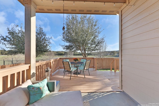 wooden terrace featuring outdoor dining space and fence