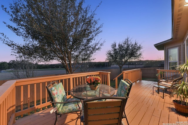 deck at dusk with outdoor dining space