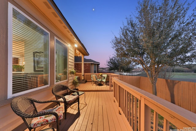 wooden deck with outdoor dining space and fence