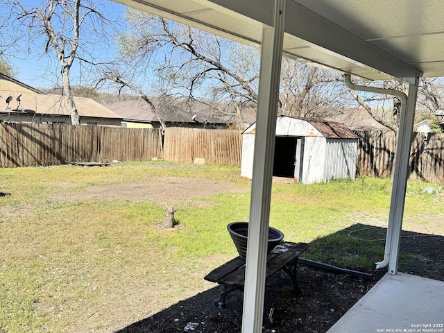 view of yard with a storage unit, a fenced backyard, and an outdoor structure