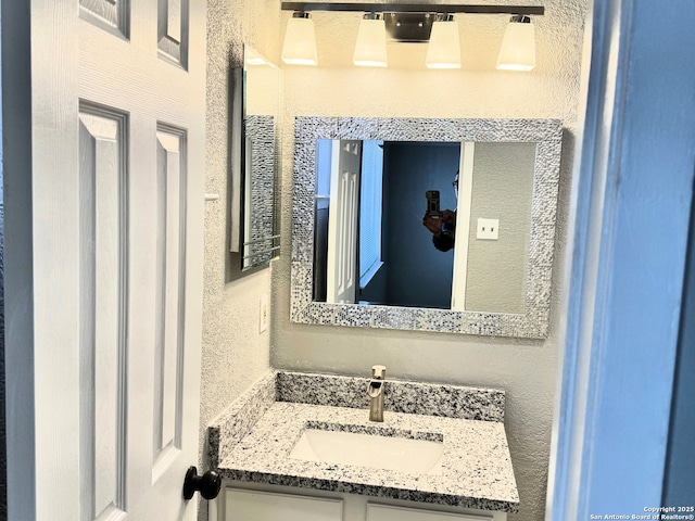 bathroom with vanity and a textured wall