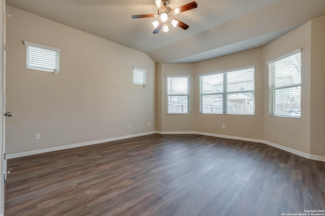 unfurnished room with a wealth of natural light, dark wood-style flooring, a ceiling fan, and vaulted ceiling