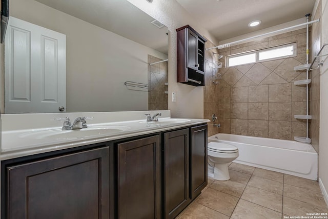 bathroom featuring tile patterned floors, toilet, shower / bathing tub combination, and a sink