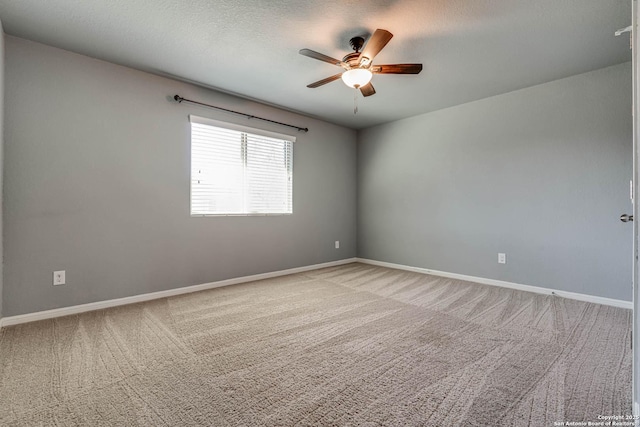 unfurnished room with a textured ceiling, light carpet, baseboards, and ceiling fan