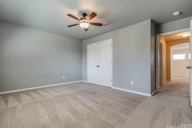 unfurnished bedroom with a closet, visible vents, baseboards, and carpet floors