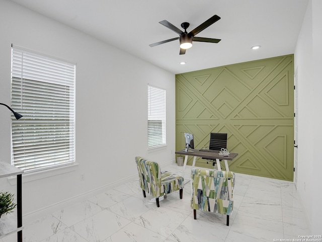 office featuring baseboards, a ceiling fan, marble finish floor, and an accent wall