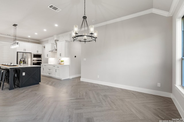 kitchen with baseboards, visible vents, appliances with stainless steel finishes, crown molding, and a chandelier