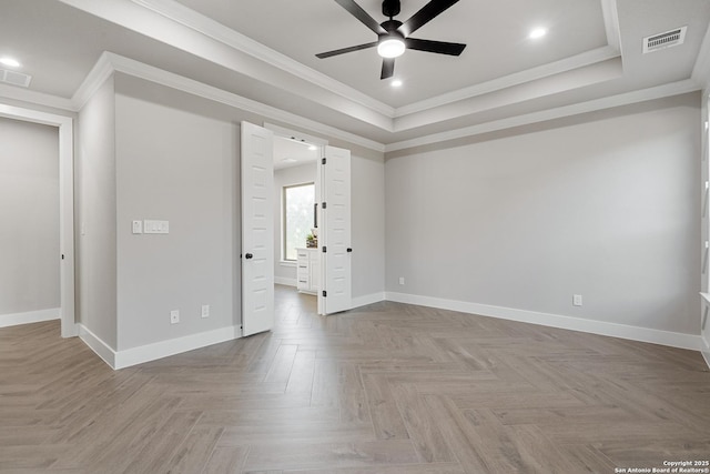 spare room featuring a raised ceiling, baseboards, visible vents, and ceiling fan