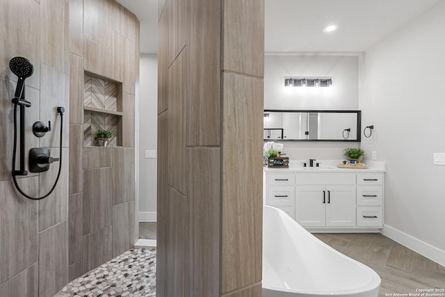 full bathroom featuring baseboards, walk in shower, recessed lighting, a soaking tub, and vanity