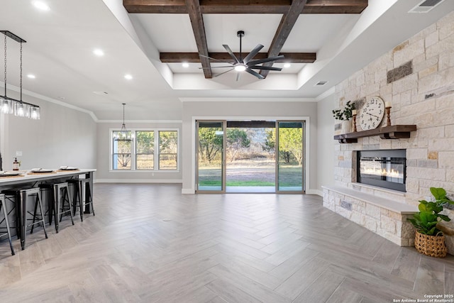 living room with a stone fireplace, beam ceiling, a ceiling fan, and baseboards