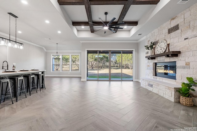 living area with baseboards, ceiling fan, beam ceiling, recessed lighting, and a fireplace