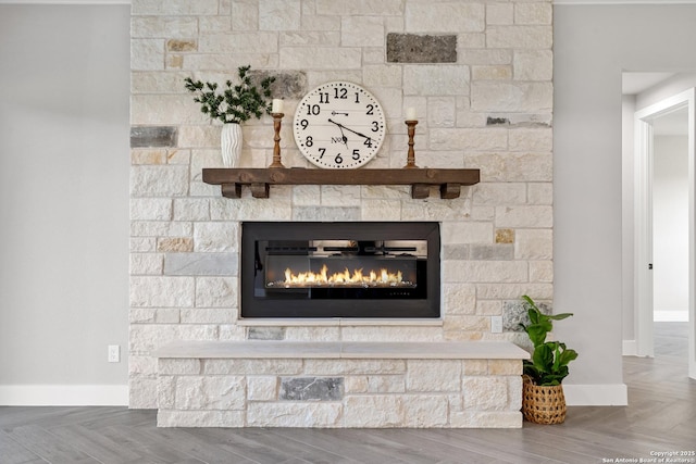 details with baseboards and a stone fireplace