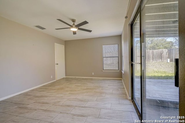 spare room with visible vents, a healthy amount of sunlight, baseboards, and ceiling fan