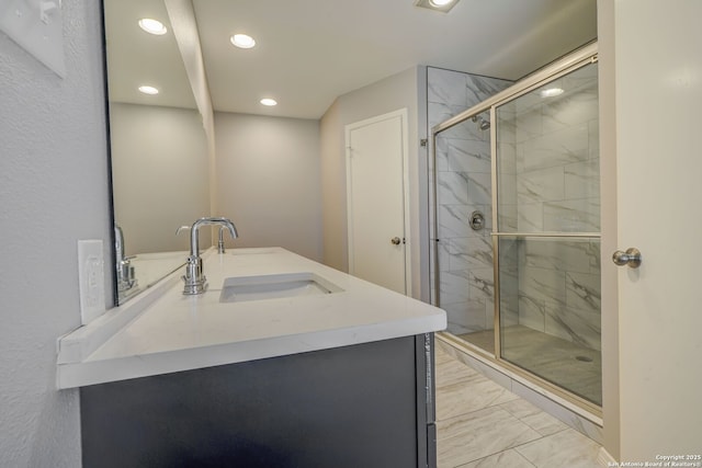 full bathroom featuring double vanity, recessed lighting, a sink, a shower stall, and marble finish floor