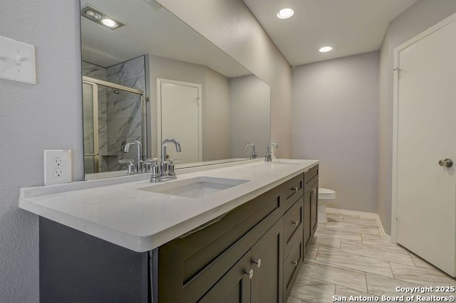 full bathroom featuring double vanity, a stall shower, toilet, and a sink