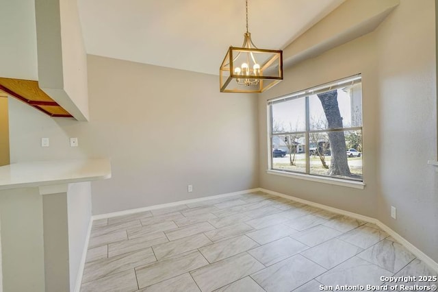 unfurnished dining area with baseboards and a chandelier