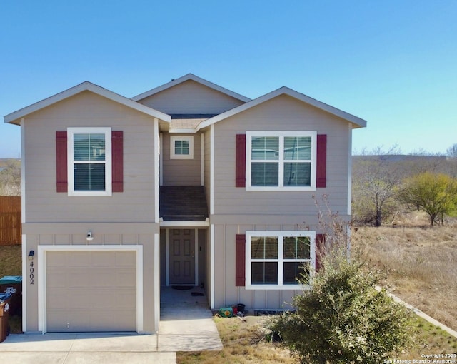 traditional home featuring concrete driveway, an attached garage, and board and batten siding