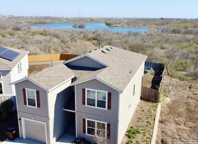 view of front of house featuring fence, a garage, and a water view