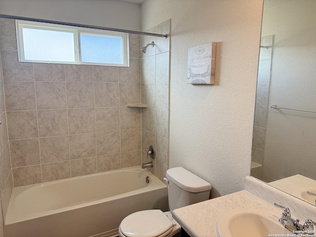 bathroom with vanity, toilet, washtub / shower combination, and a textured wall