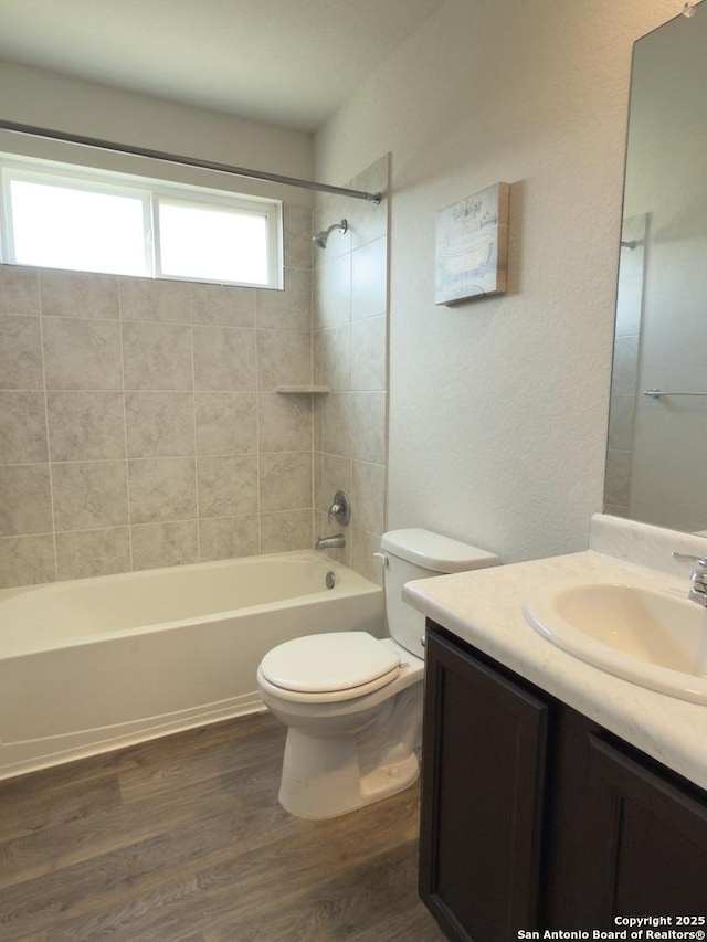 full bath featuring tub / shower combination, toilet, wood finished floors, and vanity