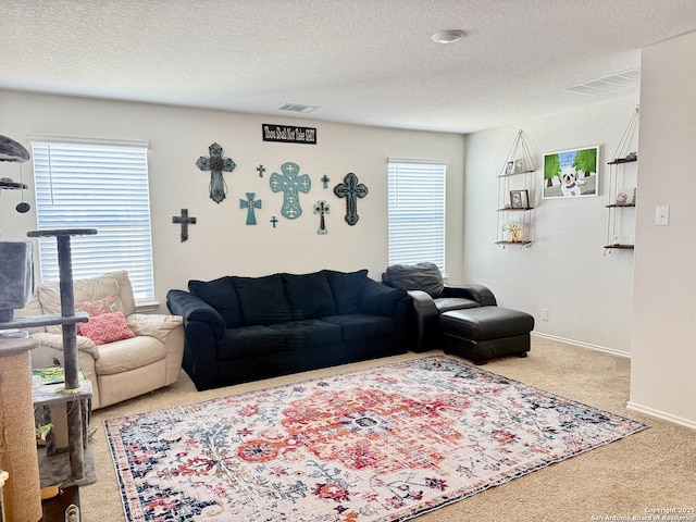 carpeted living room with visible vents, a textured ceiling, and baseboards