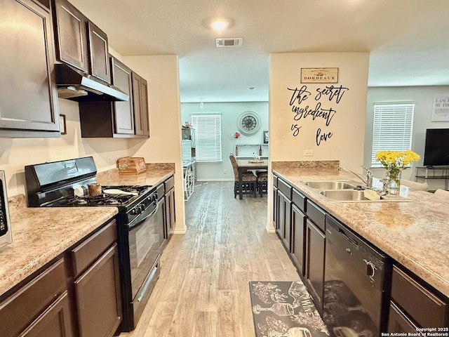 kitchen with visible vents, light wood-style flooring, black appliances, dark brown cabinets, and under cabinet range hood