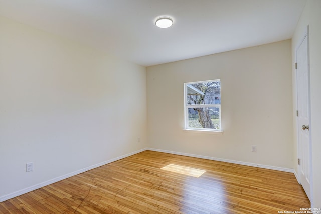 empty room with baseboards and light wood-style flooring