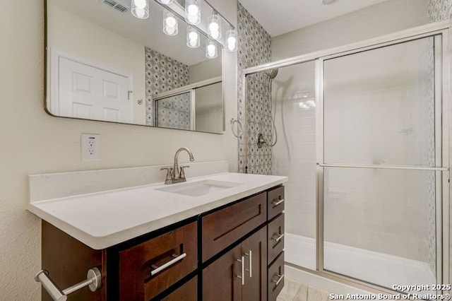 bathroom with vanity, visible vents, and a stall shower