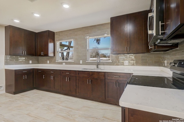 kitchen featuring recessed lighting, backsplash, stainless steel appliances, and a sink