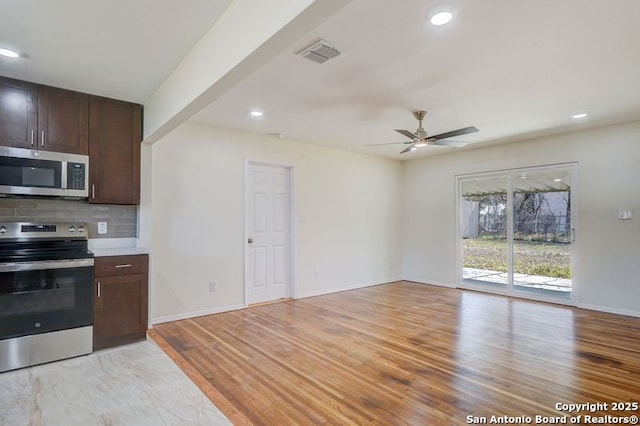 kitchen with visible vents, a ceiling fan, backsplash, stainless steel appliances, and dark brown cabinets