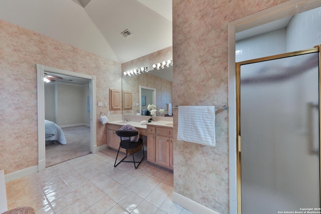 ensuite bathroom with vanity, baseboards, lofted ceiling, a shower stall, and tile patterned floors