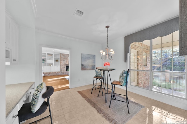 dining area with a chandelier, visible vents, built in shelves, and light tile patterned flooring