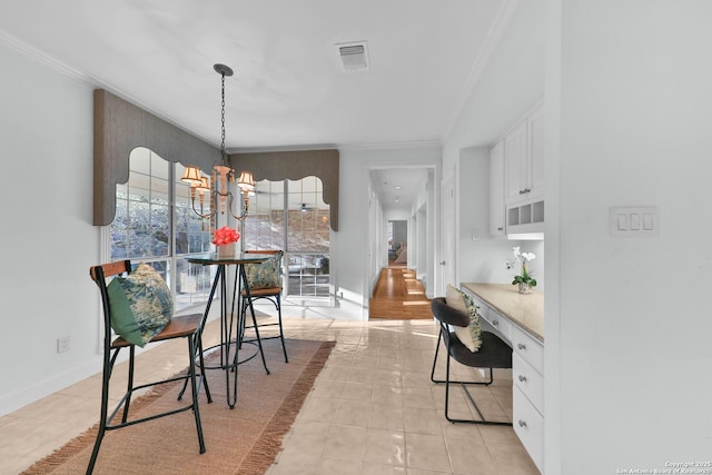 dining area featuring crown molding, a notable chandelier, baseboards, and visible vents