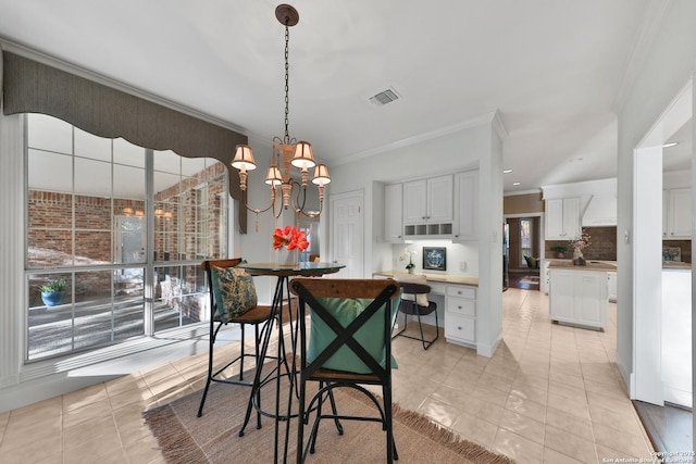 dining room with light tile patterned floors, a chandelier, visible vents, and ornamental molding