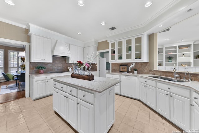 kitchen featuring light tile patterned floors, visible vents, premium range hood, a sink, and black electric cooktop