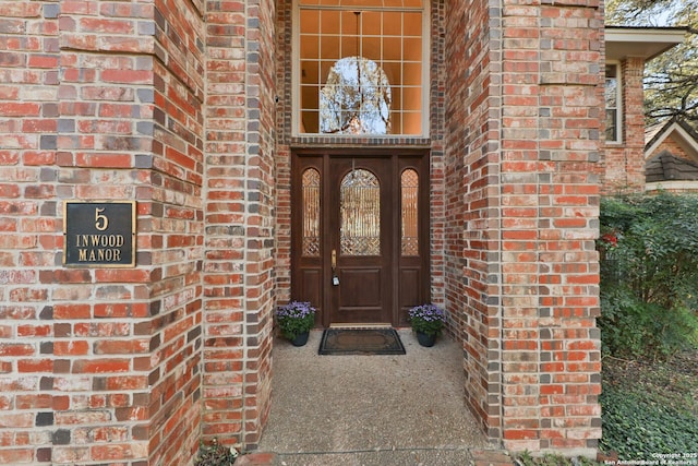 entrance to property featuring brick siding