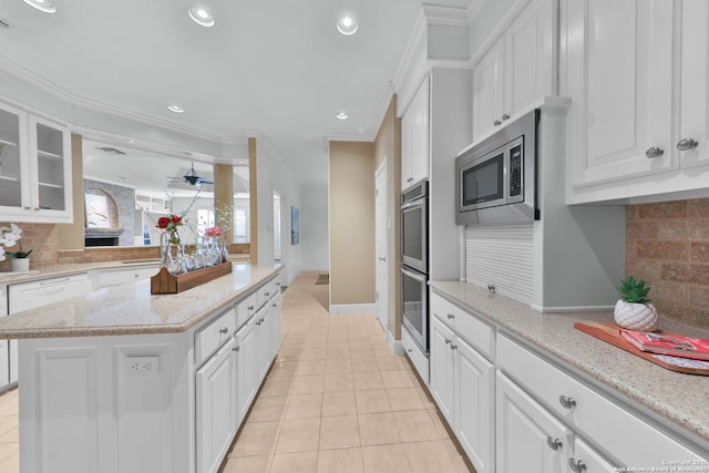 kitchen featuring recessed lighting, stainless steel appliances, white cabinets, light tile patterned floors, and glass insert cabinets