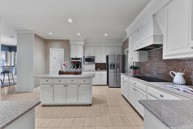 kitchen with tasteful backsplash, custom range hood, ornamental molding, stainless steel appliances, and white cabinetry