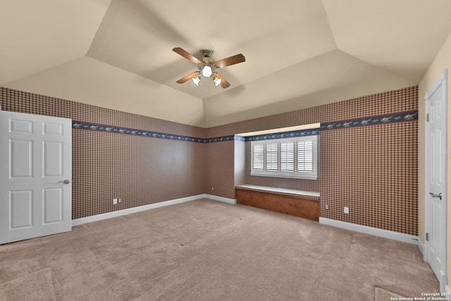 unfurnished bedroom featuring a ceiling fan, vaulted ceiling, carpet, and baseboards