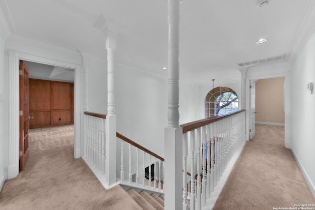 hallway with visible vents, an upstairs landing, carpet, crown molding, and baseboards