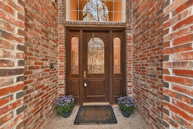 entrance to property featuring brick siding